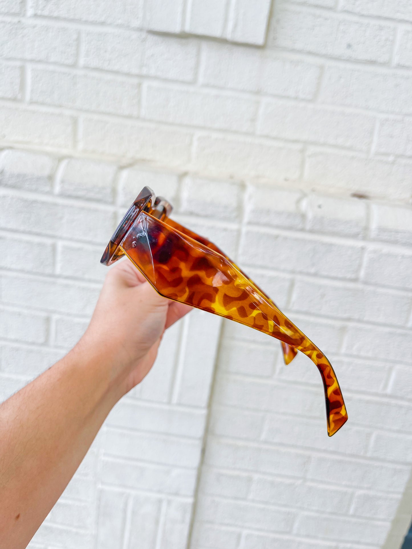 brown trendy rectangular sunglasses with tortoise print and medium sized lenses.