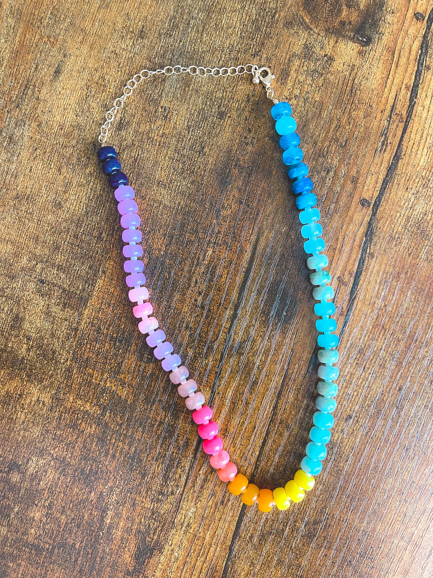 Colorful beaded necklace on a wooden surface