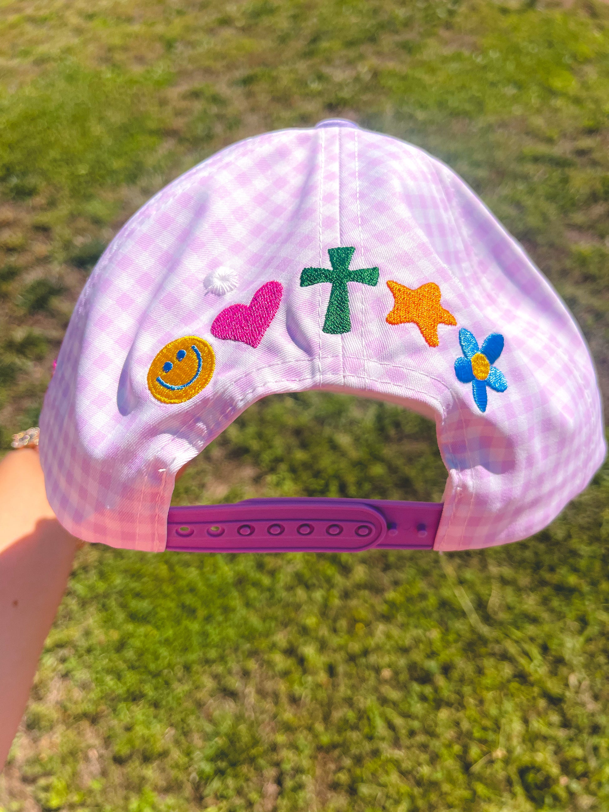 Purple cap with colorful stickers on a grassy background