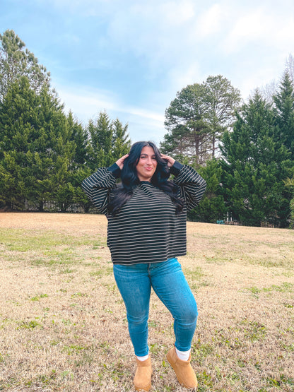 Black and white striped oversized sweater, perfect for casual outings in comfortable soft fabric paired with denim jeans.