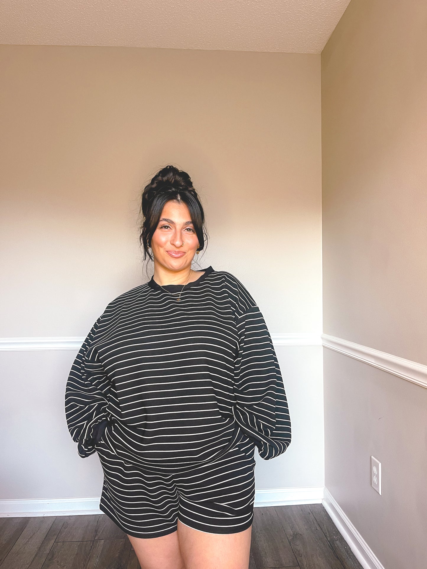 Model wearing black and cream striped loungewear set made from soft, comfortable fabric.