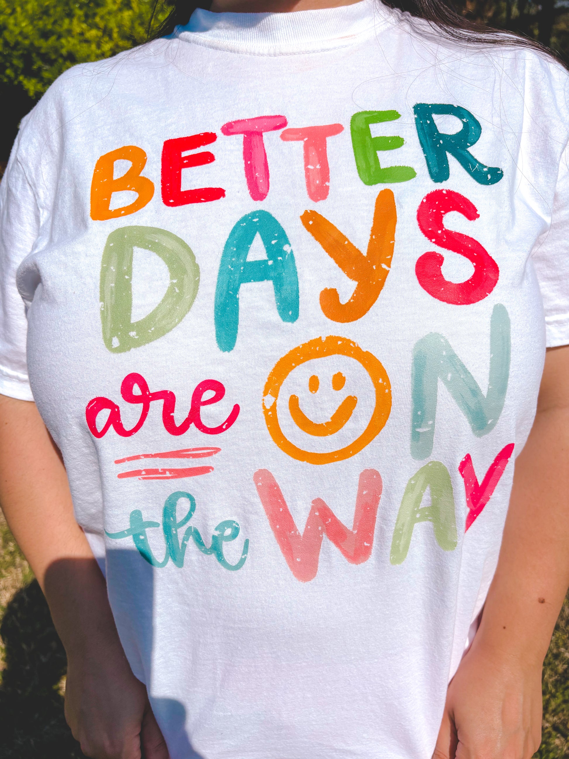 White t-shirt with colorful text 'Better Days are on the Way' featuring a smiley face.