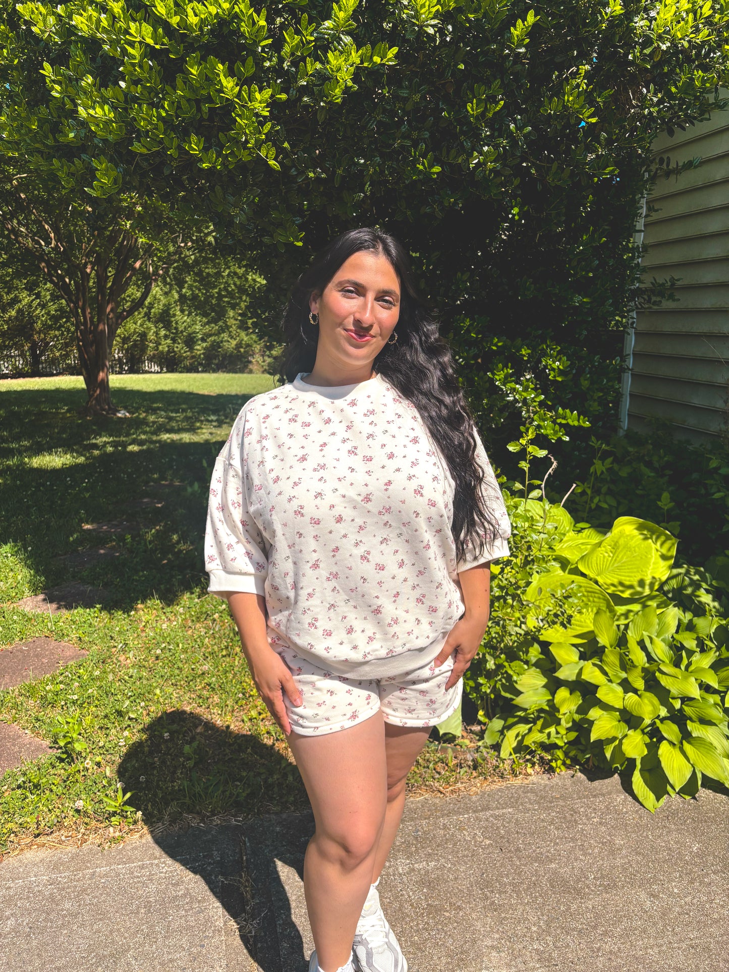 Girl standing in front of bush in floral shorts set