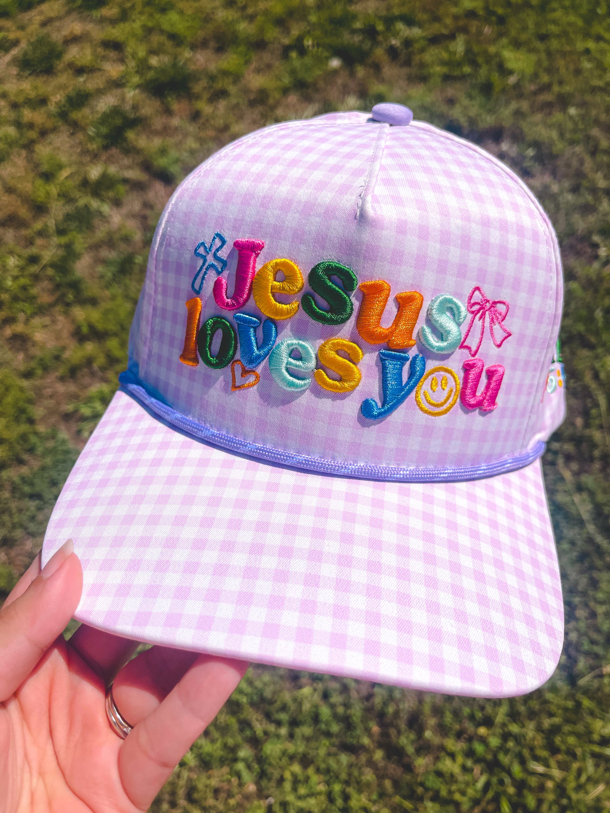 Jesus loves you purple hat on grass background