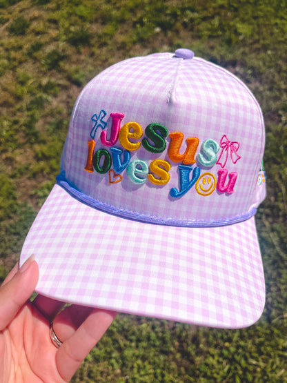 Jesus loves you purple hat on grass background