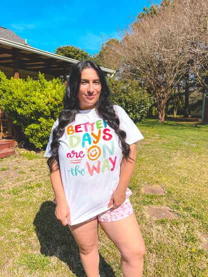 Person wearing a colorful t-shirt with text in an outdoor setting