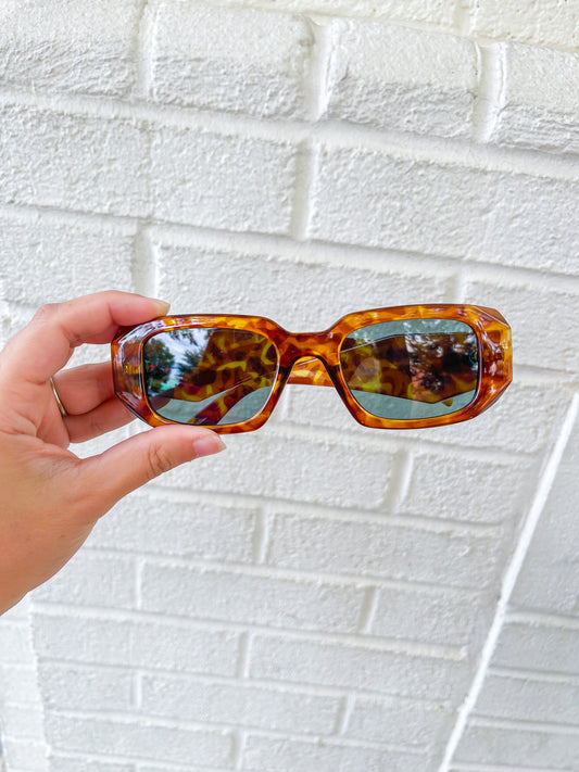 brown trendy rectangular sunglasses with tortoise print and medium sized lenses.